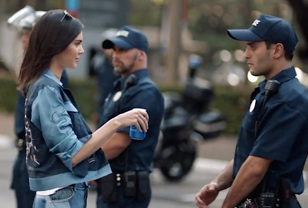 Kendall Jenner hands a can of Pepsi